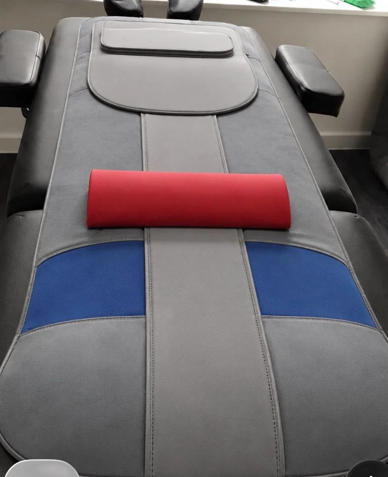 Grey assisted stretching mat with blue panels and a red bolster